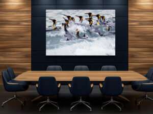 A group of king penguins navigating the crashing ocean waves, their vibrant golden markings contrasting with the dynamic blue of the water, exemplifying strength and unity in the wild.