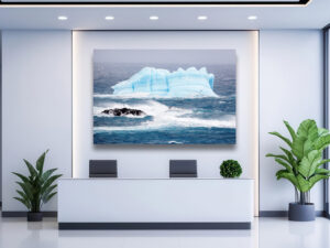 A lone Imperial Shag soars past a massive blue iceberg in the Southern Ocean, with turbulent waves and dramatic light capturing the wild beauty of nature.